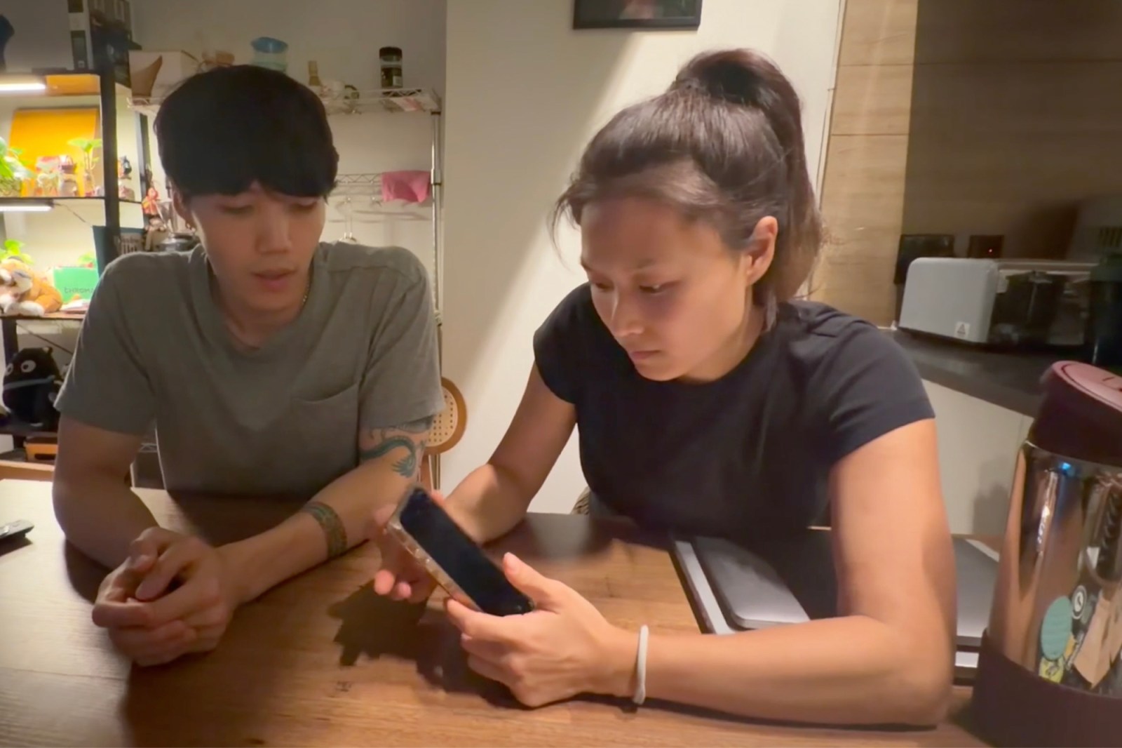 Bill and Yelim Kim watching security footage on their phones