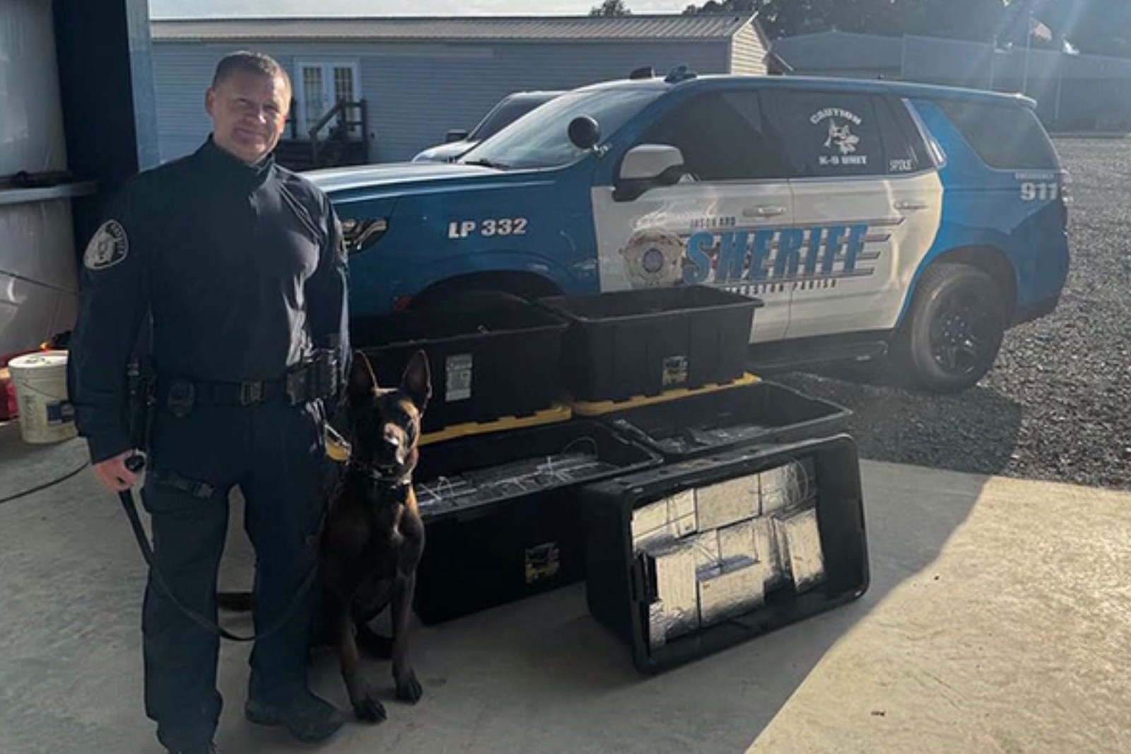 A K9 unit beside bins of seized methamphetamine in Livingston Parish